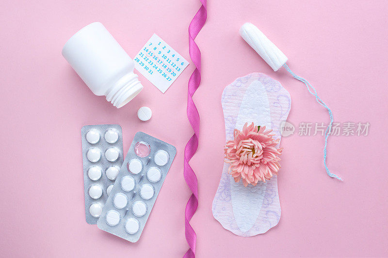 Tampon, sanitary pads for critical days, female calendar, pain pills during menstruation and a pink flower on a pink background. Care of hygiene during menstruation. Regular menstrual cycle. Monthly protection